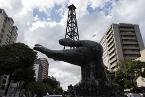 A sculpture depicting an oil derrick resting in an open hand is seen outside the PDVSA building ahead of government debt meetings in Caracas, Venezuela, in November. Foto: Carlos Becerra, Bloomberg News