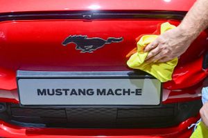 Ingen fedtede fingre. En Ford Mustang Mach-E bliver nusset og pudset på førstedagen af biludstillingen IAA Mobility 2021 i München. Foto: AFP/Tobias Schwarz  