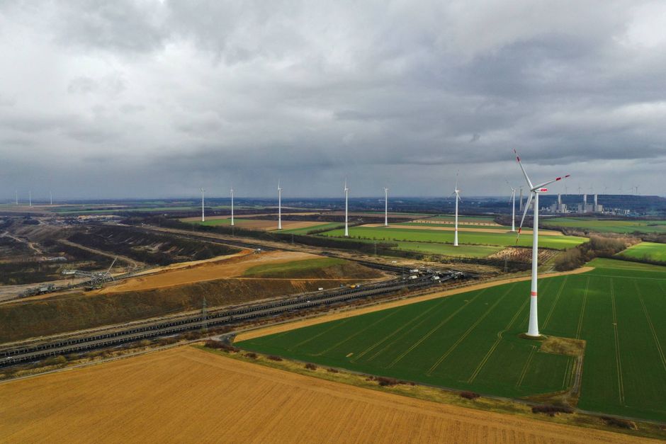 Wind turbines, operated by RWE AG, operate beside the Garzweiler open cast lignite mine in this aerial photograph taken in Grevenbroich, Germany, on Monday, March 15, 2021. Axa SA, France's biggest insurer, is dropping German energy giant RWE as a client in a decision that highlights how taboo the coal business has become. Bloomberg photo by Alex Kraus