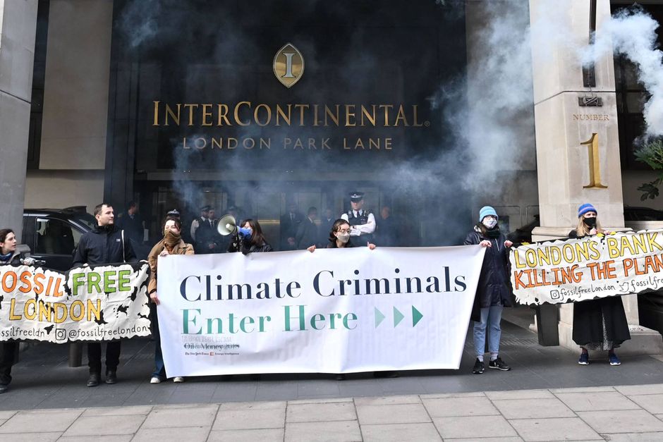 Klimaaktivister blokerer indgangen til InterContinental Park Lane i London, hvor en stor del af International Energy Week 2023 finder sted. Det store banner er i øvrigt genbrug fra konferencen Oil & Money 2018, der fandt sted samme sted. Foto: AFP/Justin Tallis 