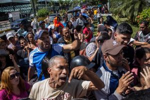 Vreden er stor i køen foran et supermarked i Caracas, hvor de fleste hylder er tomme. Foto: AP/Rayner Pena