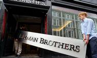 Sindbilledet på en nedsmeltning: Skiltet, der hang over Lehman Brothers afdeling i London, bæres ind på Christies auktioner for at bliver bortauktioneret som en finanskrisesourvenir. Finanskrisen i 2008 ramte også Danmark hårdt, og mange af dem, der dengang blev ledige, er nu ramt af coronakrisen, viser en analyse fra AE. Arkivfoto: AP/Kirsty Wigglesworth