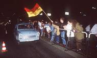 En Trabant – for mange selve symbolet på Østtyskland – hoster med sin totaktsmotor over grænseovergangen Bornholmer Straße fra Øst- til Vestberlin den 9. november 1989 – den aften, da Berlinmuren faldt. Foto: AP/Sven Simon