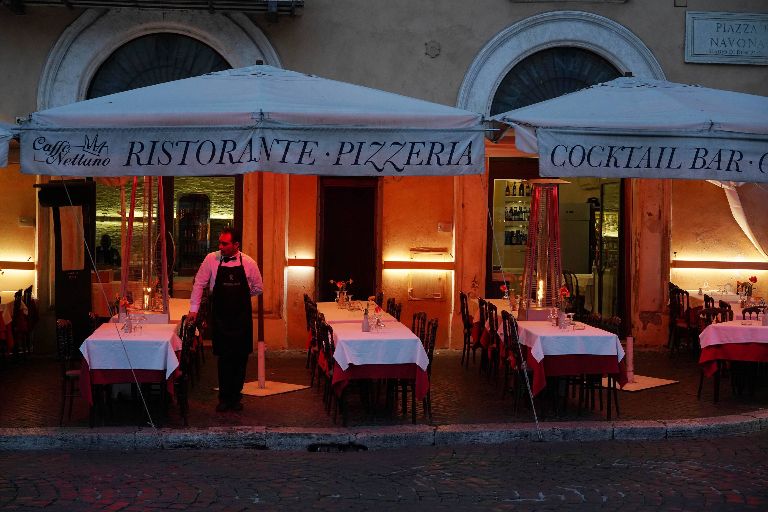 På Piazza Navona i Rom venter en tjener forgæves på gæster. Det kan have lange udsigter, inden de vender tilbage. Foto: AP/Andrew Medichini