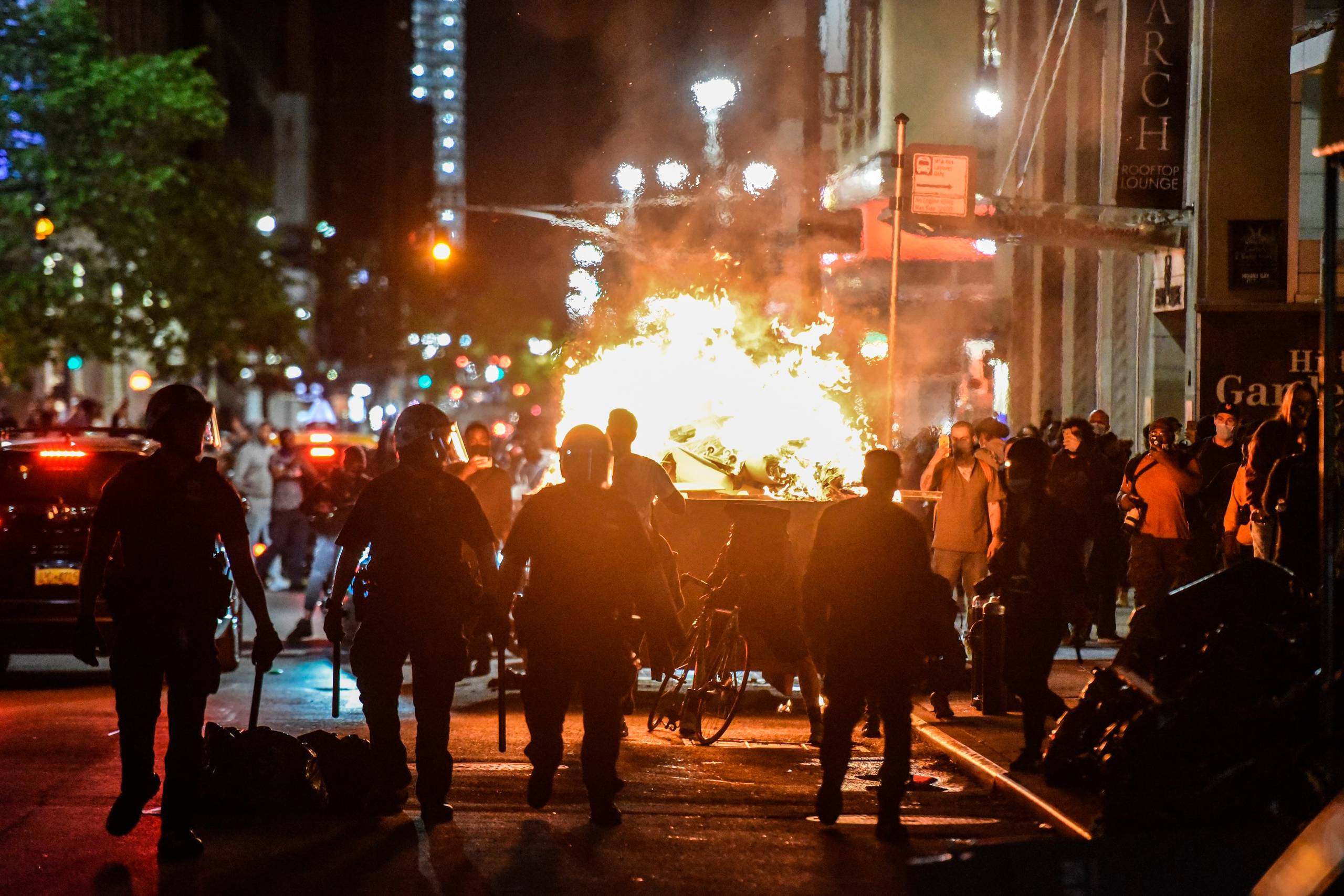 I flere amerikanske storbyer er der indført udgangsforbud. På dette billede fra New York ses demonstranter, der har sat ild til en container.Foto: Stephanie Keith/Getty Images/AFP