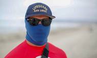Badesæsonen er begyndt i Californien, og livredderinstruktør Christopher Zang viser den personlige beskyttelse, der skal bæres af livredderne på strandene ved San Diego for at forebygge en 2. smittebølge. Foto: Reuters/Mike Blake