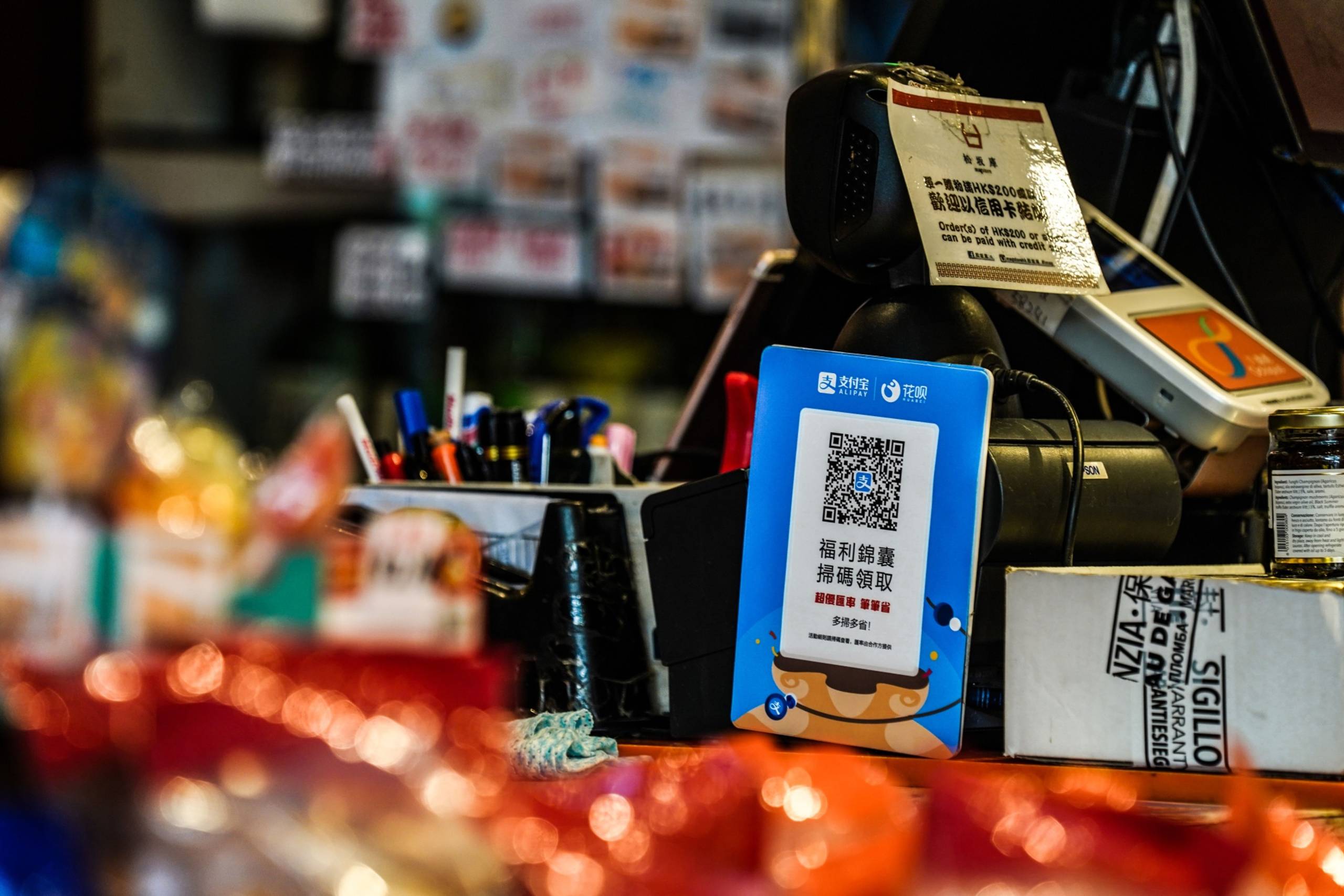 A sign for digital payment service Ant Financial's Alipay, an Alibaba affiliate, in front of a payment terminal of a store in Hong Kong on July 21, 2020. Foto: Bloomberg/Lam Yik