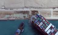 Turister betaler for at se Ever Given. De må ikke komme ombord, men kan sejle forbi containerskibet i en færge. Foto: AFP Photo/Satellite image, Maxar Technologies