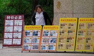 En række skilte med boliger ved et salgskontor i Beijing. Foto: Andy Wong/AP/Ritzau Scanpix