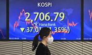 En kvinde går forbi en skærm, der viser Sydkoreas Kospi-aktieindeks. Sydkorea har klaret sig ganske pænt gennem pandemien, båret frem af eksporten. Foto: Jung Yeon-je/AFP