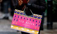 (FILES) In this file photo taken on December 10, 2019 a customer carries a Ted Baker-branded shopping bag after leaving a store in London. - The British clothing chain Ted Baker has accepted a 211 million pound takeover offer from the American Authentic Brands Group (ABG), owner of the sportswear brands Reebok and Juicy Couture in particular, according to a press release on August 16, 2022. (Photo by Tolga Akmen / AFP)
