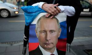 En kvinde holder et billede af den russiske præsident, Vladimir Putin, under en pro-russisk demonstration i den serbiske hovedstad Beograd. Foto: Darko Vojinovic/AP/Ritzau Scanpix
