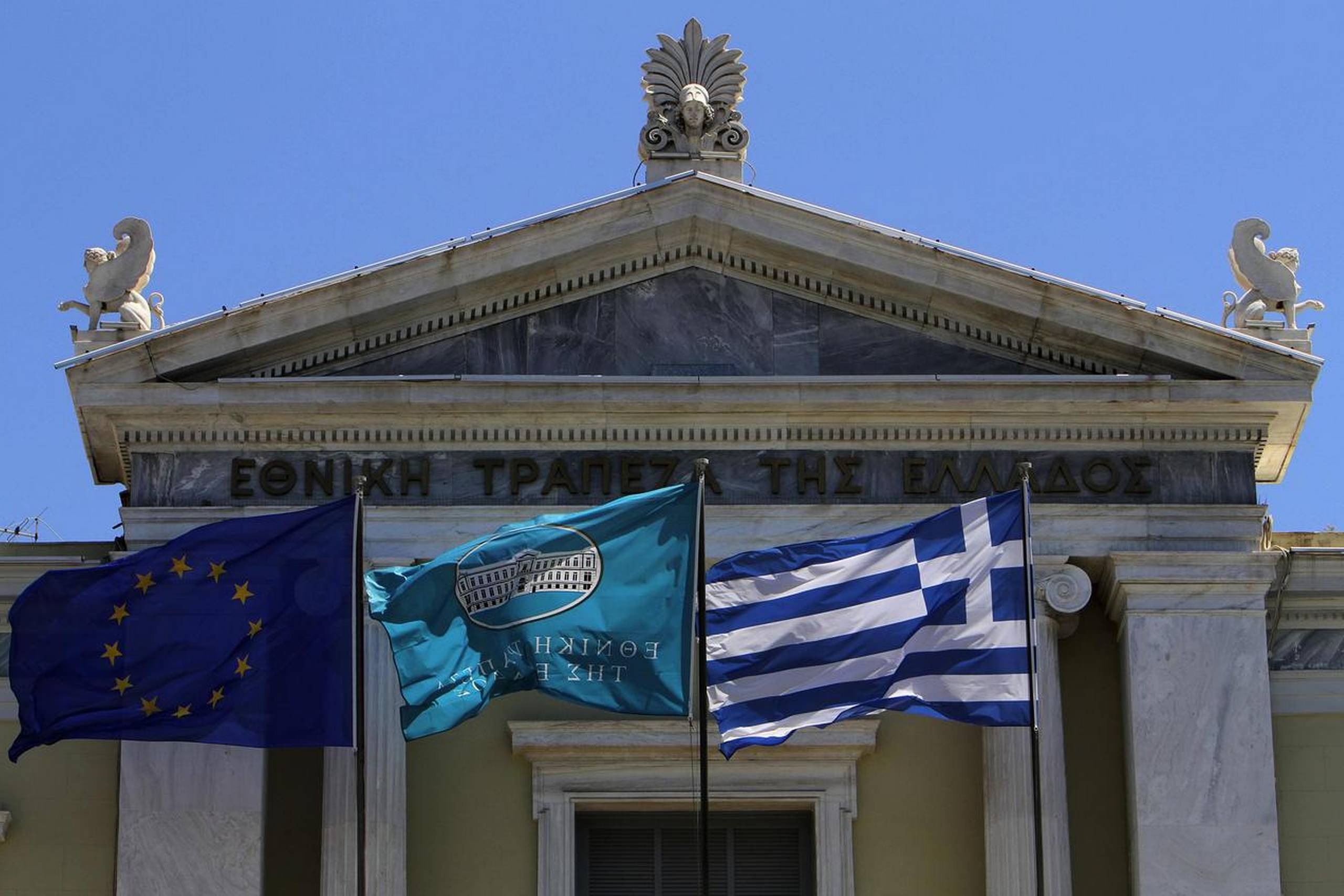 Det officielle flag for National Bank of Greece vajer side om side med det europæiske og det græske flag. Investorerne frygter, at valget i Grækenland kan medføre, at EU vil stryge flaget.