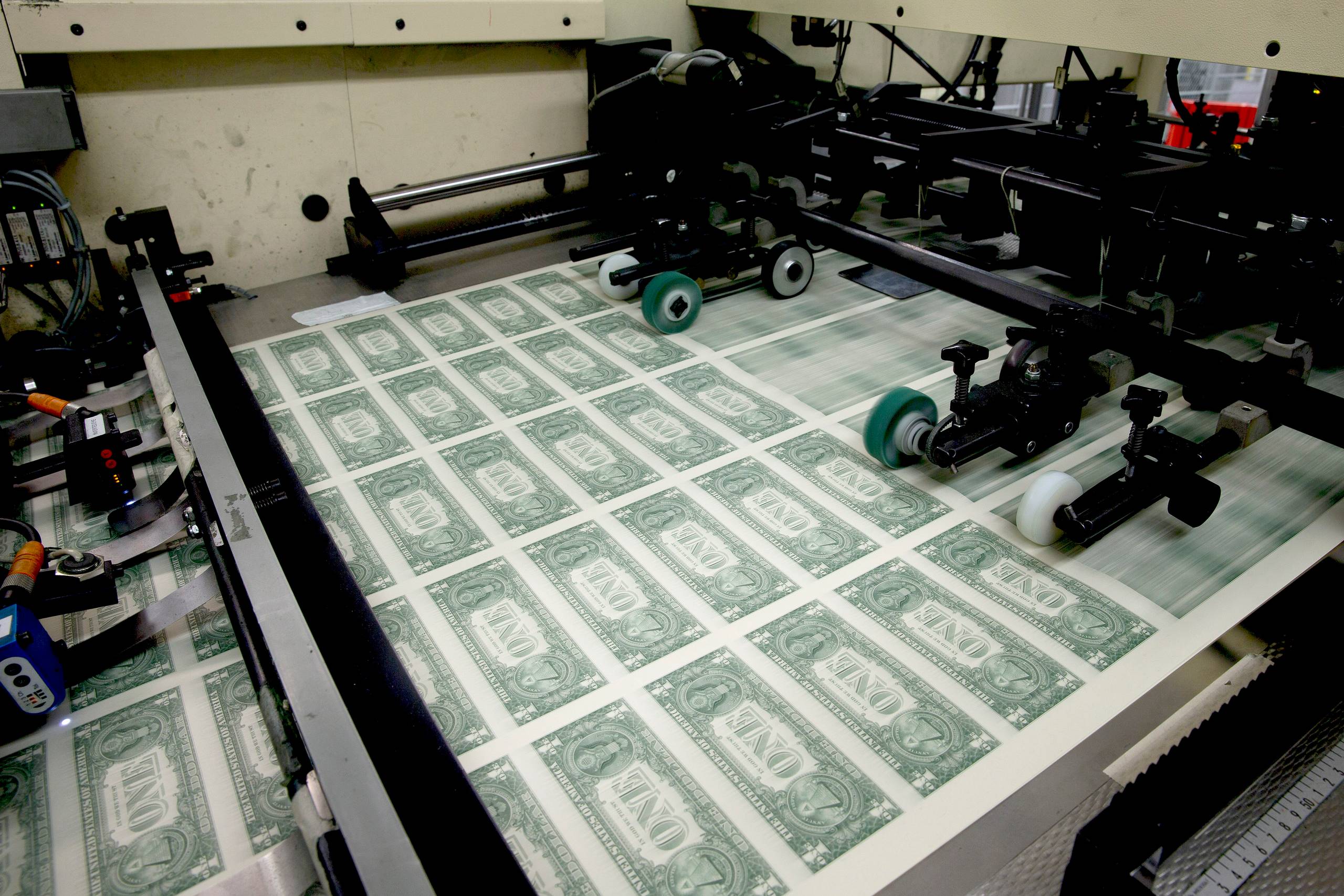One dollar bills are run through a printing press at the U.S. Bureau of Engraving and Printing in Washington in April. A school of dissident economists is challenging the conventional wisdom that budget deficits are dangerous. 
