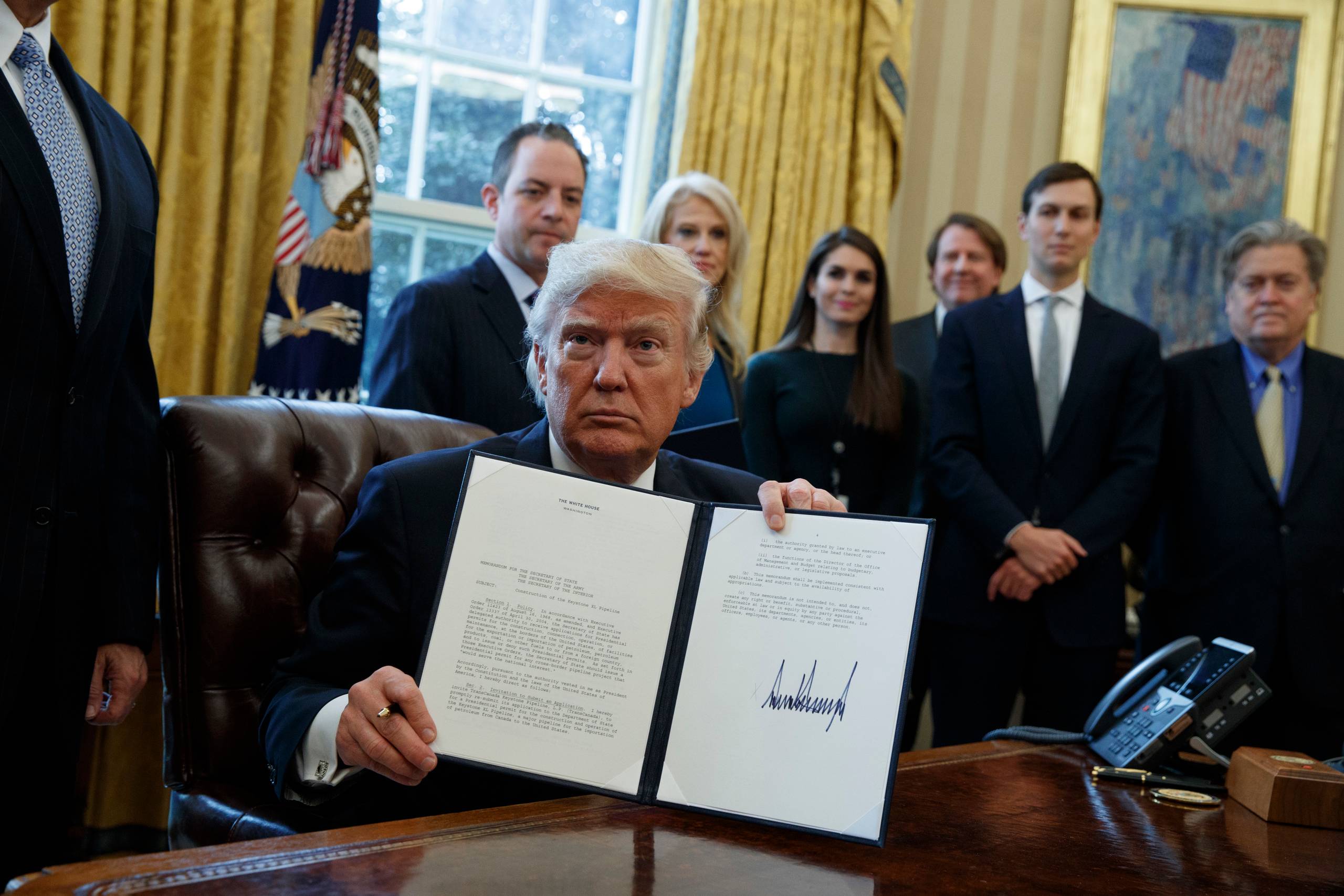Præsident Trump fremviser det netop underskrevne dekret, der giver tilladelse til byggeriet af olierørledningerne Keystone XL og Dakota Access. Foto: AP/Evan Vucci