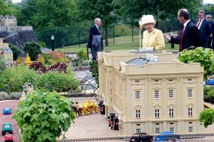 Britain's Queen Elizabeth II passes a model of Buckingham Palace at Legoland in Windsor, England, Tuesday, June 10, 2003. The Queen, along with other members of the royal family were celebrating a day of British Tourism. The queen's visit to the theme park included a walk through Mini-Land viewing models of central London. Foto: AP/Dave Caulkin